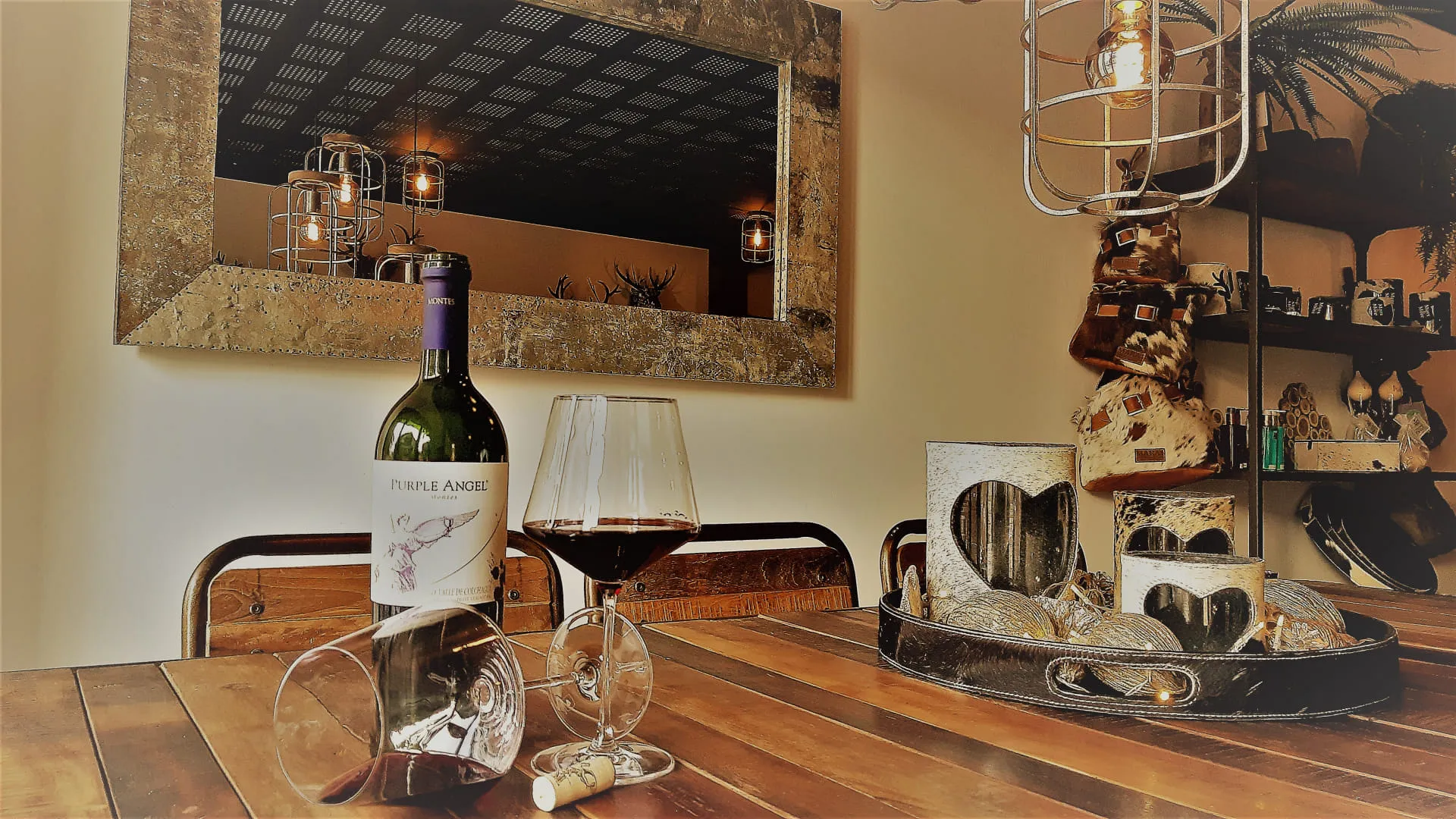 Weinflasche und Glas auf einem Tisch mit Dekoration und Spiegel im Hintergrund